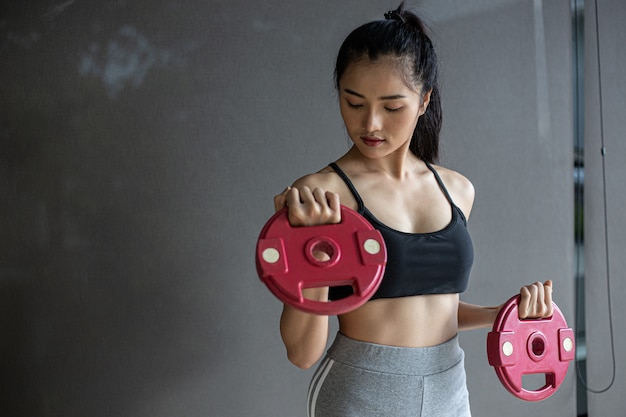 Free photo women exercising with two dumbbell weight plates