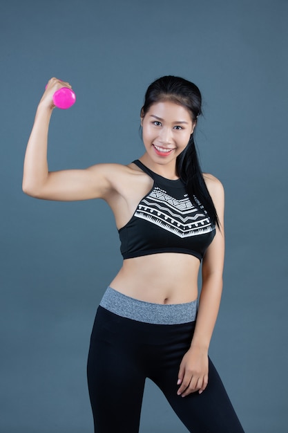Women in fitness wear hold dumbbells