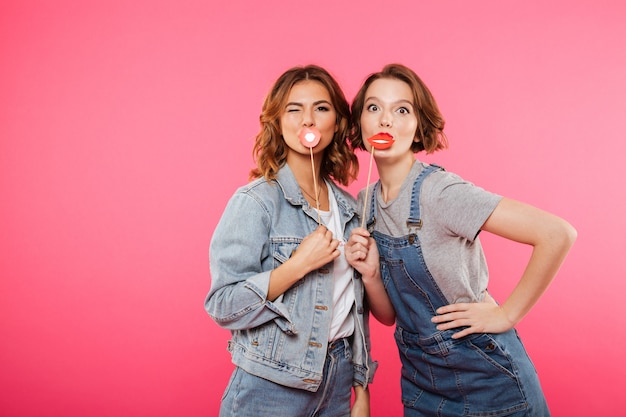 Women friends holding fake lips.