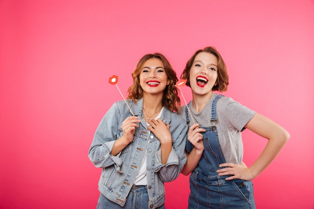 Women friends holding fake lips.