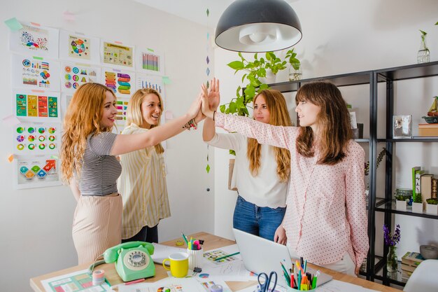 Women giving high five in office