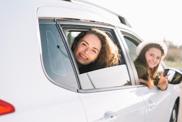 車の窓からぶら下がっている女性