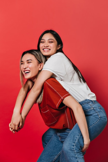 Women having fun on red wall