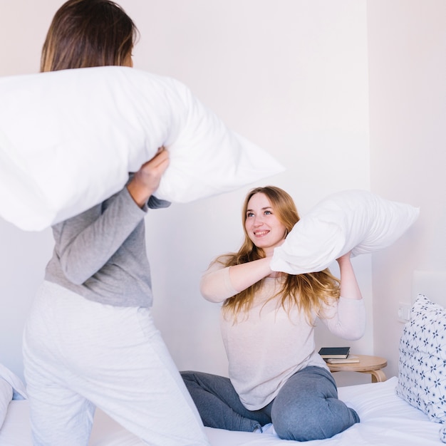 Free photo women having pillow fight