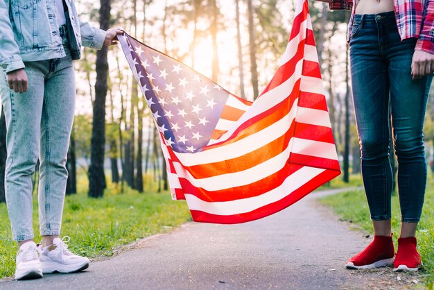 公園でアメリカの国旗を保持している女性