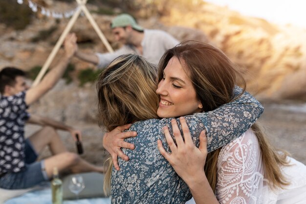 Women hugging at the beach during a get-together