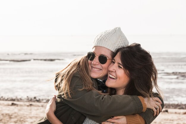 Women hugging on sea background