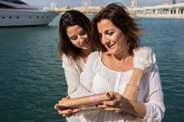 Women looking at gift near sea