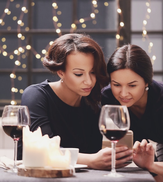 Women looking at smartphone in restaurant