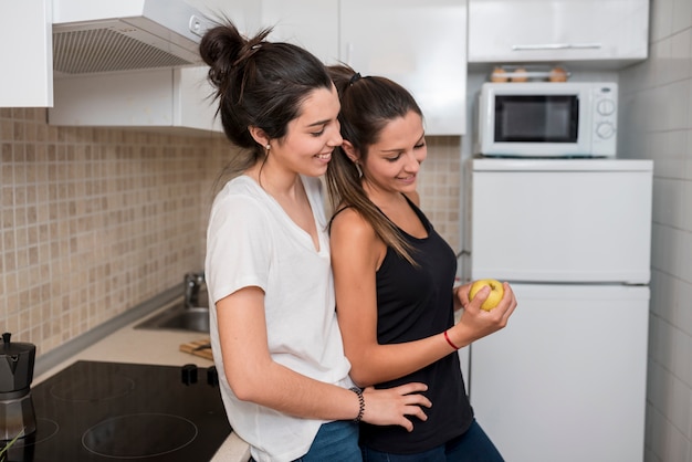 Women in love hugging in kitchen