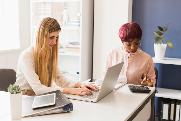 Women making calculations in office