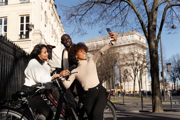 Women and man taking selfie riding bikes in the city in france