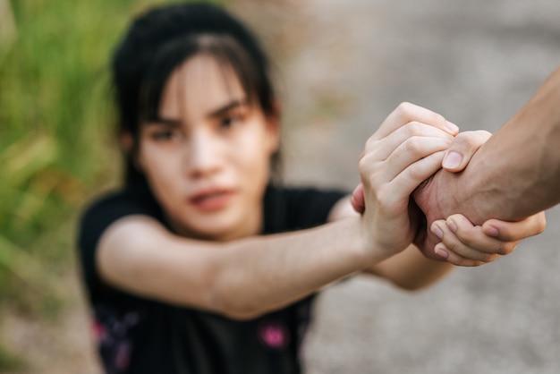 Women and men stand holding hands to exercise.