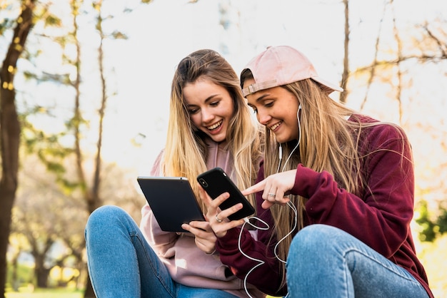 Free photo women outdoor in park using mobiles