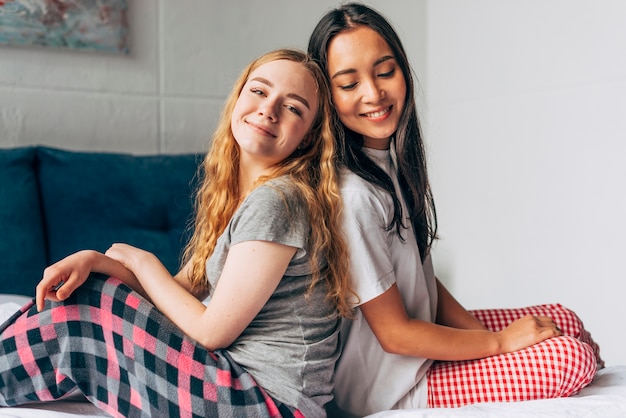 Free photo women in pajamas sitting on bed