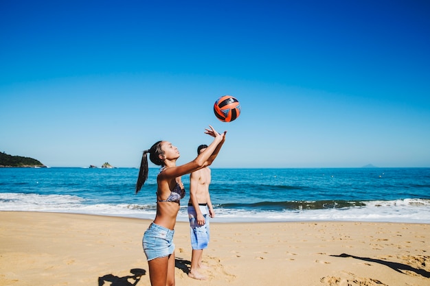 Женщины играют в пляжный волейбол