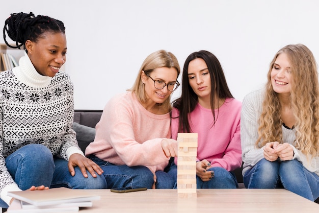 Women playing a wooden tower game