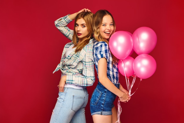 Women posing with big gift box and pink balloons