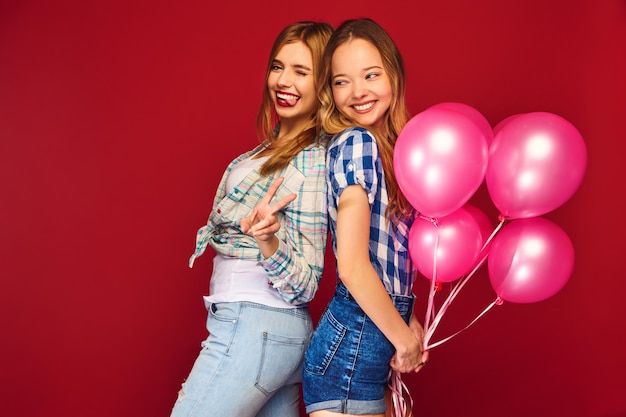 Women posing with big gift box and pink balloons