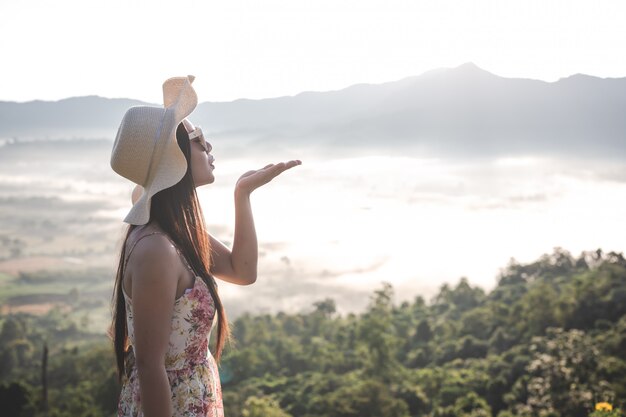 山の空きスペースで手を上げる女性