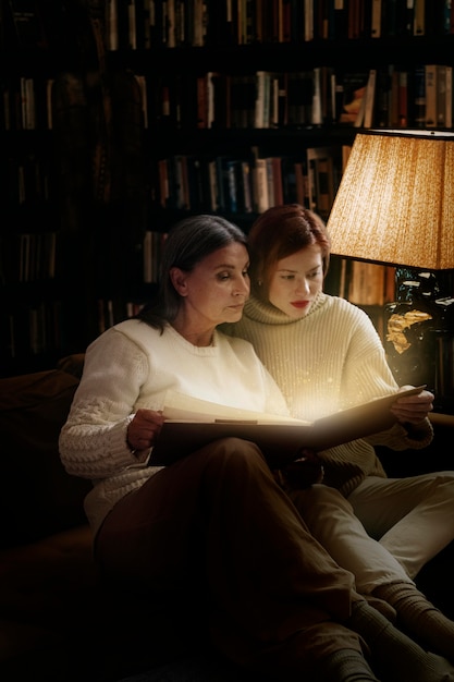 Women reading from a glowing book