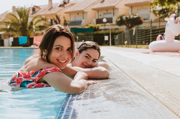 Женщины, расслабляющие рядом с бассейном