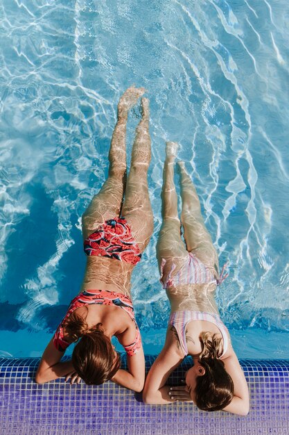 Women relaxing next to swimming pool