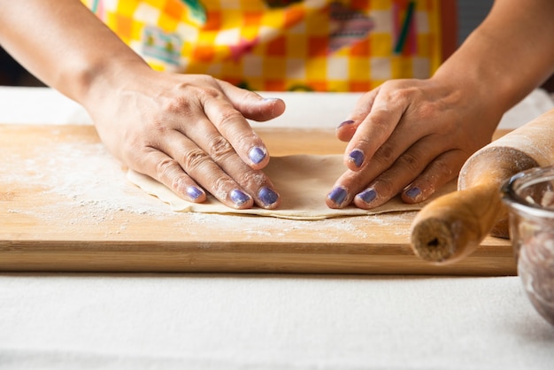 Женские руки лепят тесто для азербайджанского блюда гутаб.