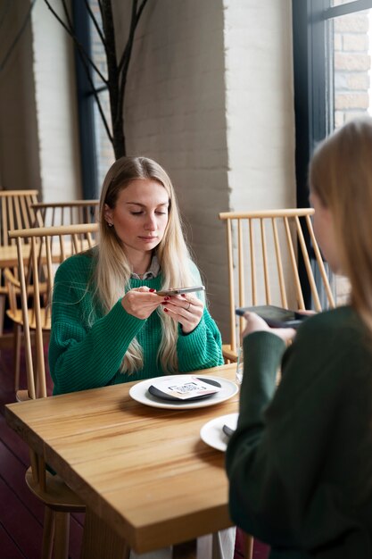 レストランでqrコードをスキャンする女性