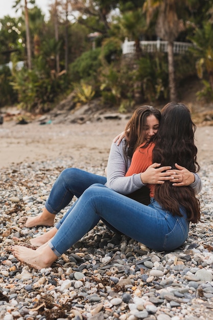 Women at seaside hugging