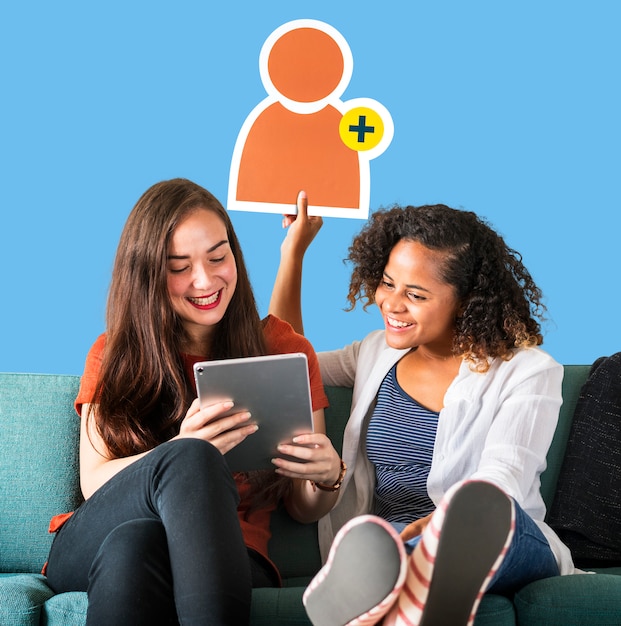 Free photo women showing a friend request icon and using a tablet