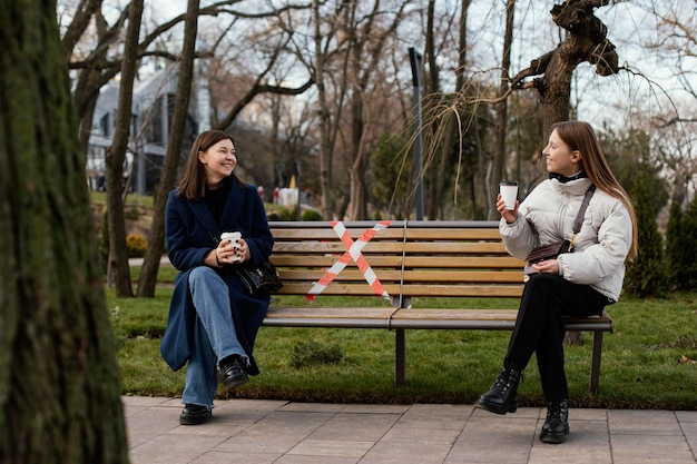 Women sitting at distance and wearing mask