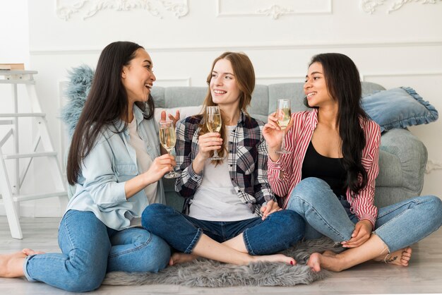 Women sitting on floor drinking champagne