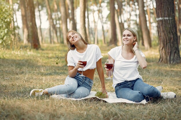 ピクニックに座ってワインを飲む女性