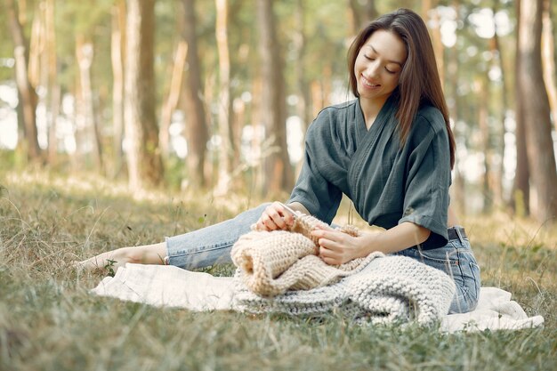 夏の公園に座っていると編み物をする女性