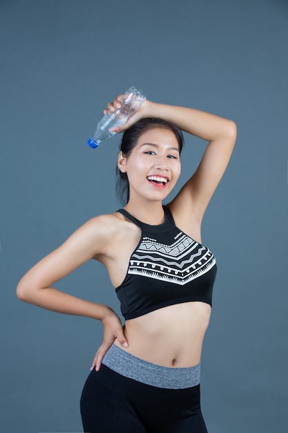 Women in sportswear hold a bottle of drinking water