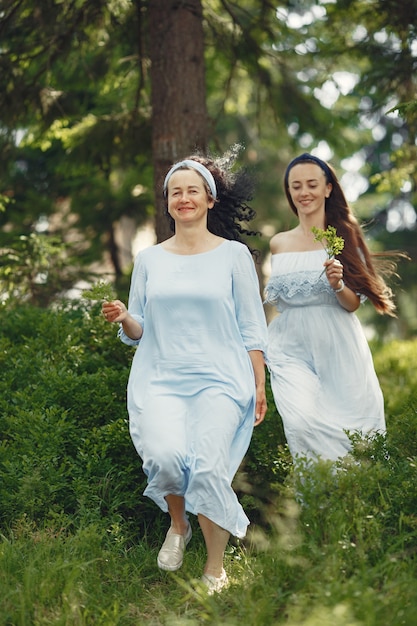 夏の森の女性。青いドレスを着た女性。家族のポーズと抱擁。