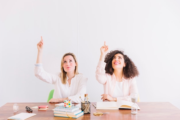 Women at table pointing up