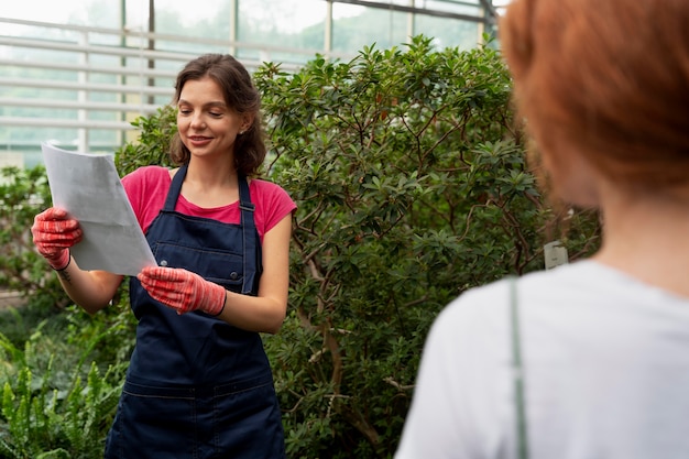 温室で植物の世話をしている女性