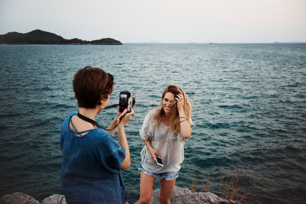 Женщины фотографируют по берегу моря