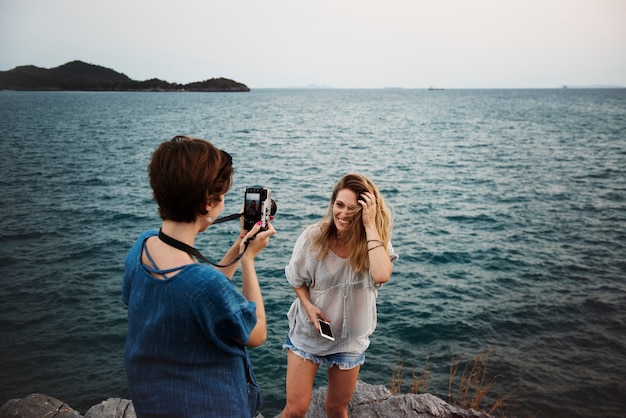 Women taking photo by seashore