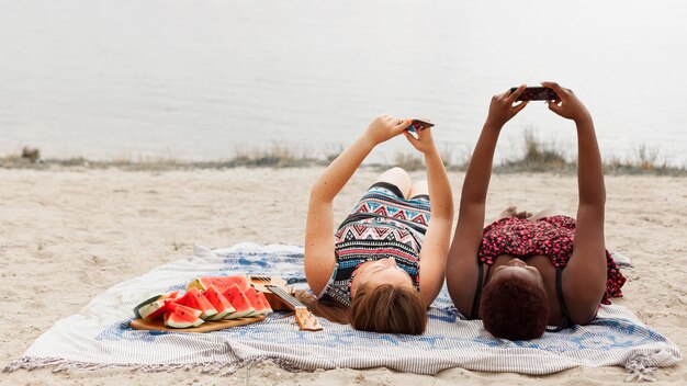 Donne che prendono selfie sulla spiaggia