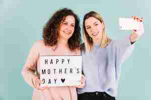 Free photo women taking selfie with mother's day greeting