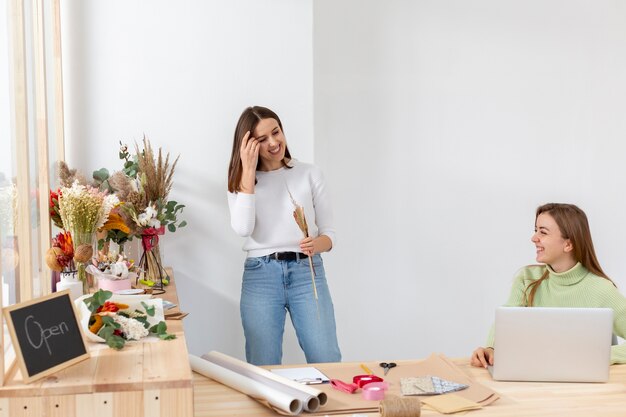 Women in their flower shop being happy