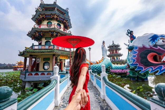 Women tourists holding man's hand and leading him to Kaohsiung's famous tourist attractions in Taiwan.