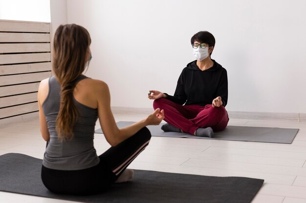 Women training together after coronavirus with medical masks on