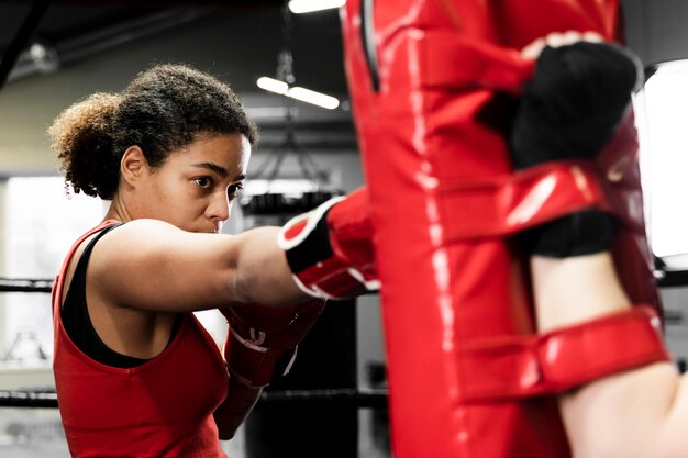 Женщины вместе тренируются в боксерском центре