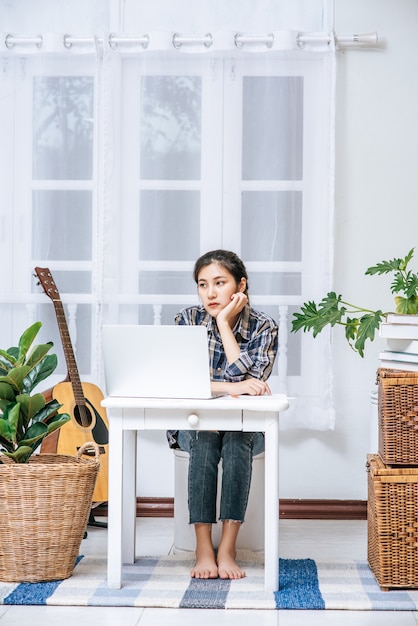 Women use a laptop at their desks and are stressed.