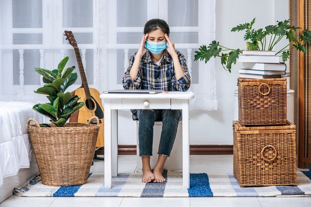 Women use a laptop at their desks and are stressed.