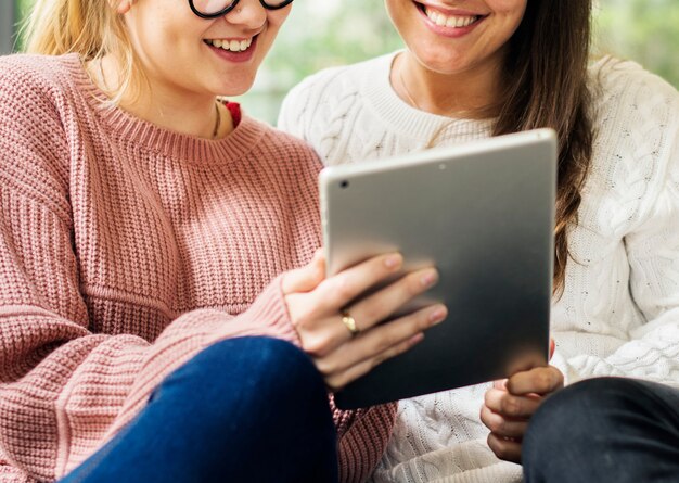 Women using digital tablet together